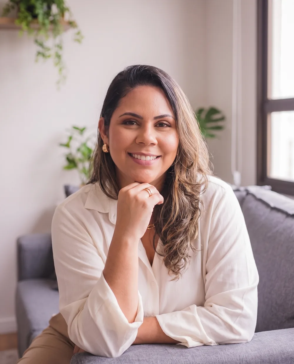 Ellen Forest sorrindo, sentada na sala, de blusa clara.