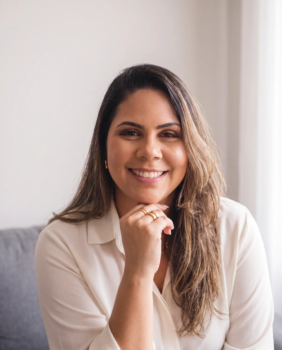 Ellen Forest, psicóloga e criadora da Tranquilizamente, sorrindo, com a mão apoiada no queixo.